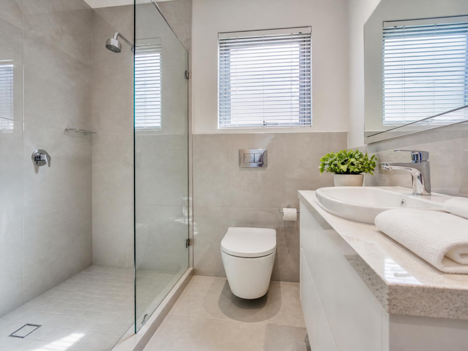 Sparkling modern bathroom with polished tiles and glass shower